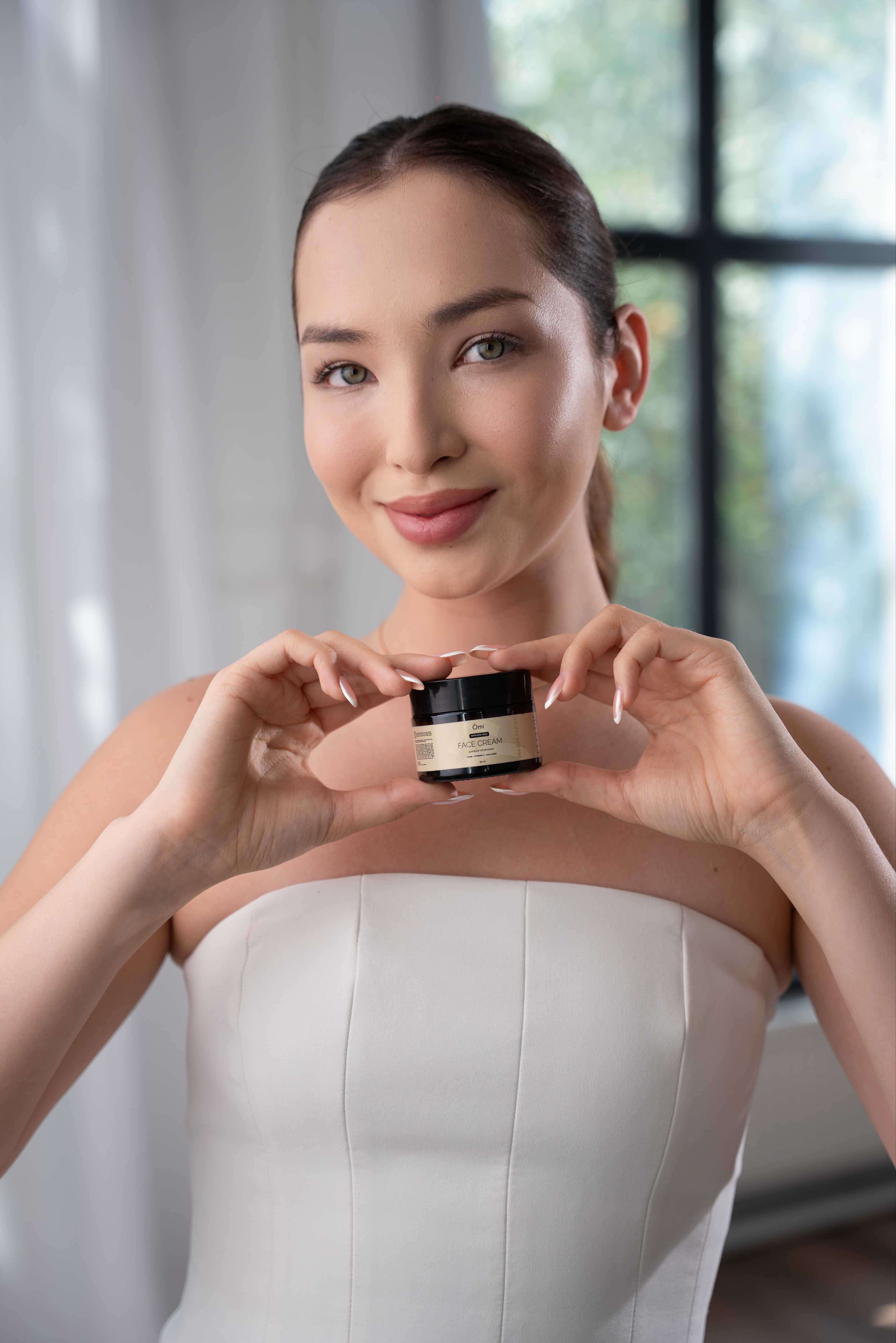 Девушка держит баночку крема OMI Face Cream